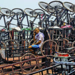 A man speaks on his mobile phone among parked trishaws in Kolkata