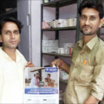 Pharmacists in Rajasthan with a MedCords poster.