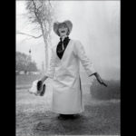 Jill Kennington wearing white PVC rain tunic and hat. Photograph by John Cowan, 1963. © Ernestine Carter Archive, Fashion Museum Bath.