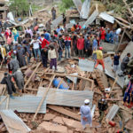 People look on the damaged house where Commander-in-Chief of Hizbul Mujahideen Riyaz Naikoo killed