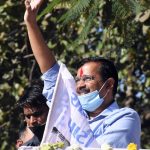 Delhi CM Arvind Kejriwal waves to his supporters during a roadshow,