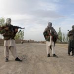 Members of the Taliban stand at the site of the execution of three men in Ghazni Province