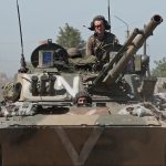 Service members of pro-Russian troops ride an infantry fighting vehicle in Popasna