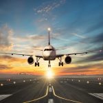 Airplane landing to airport runway in sunset light