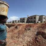 A woman walks past a Chinese construction site in Lubango