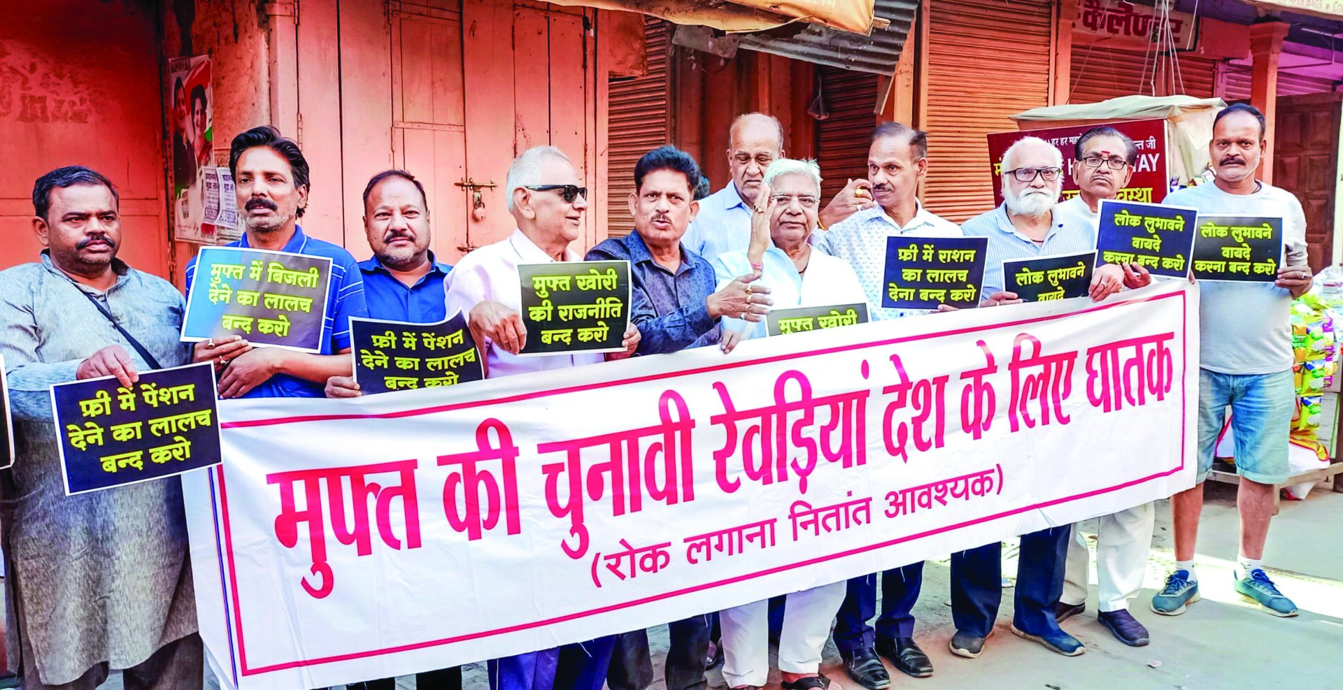 Subah-e-Banaras members hold a banner as they stage a protest against the distribution of freebies by the political parties ahead of the Lok Sabha elections, in Varanasi on April 3. ANI