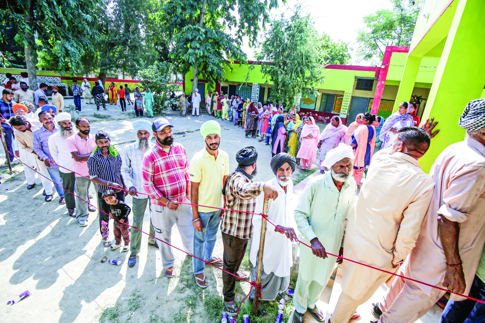 Villagers stand in queues to cast their votes at a polling station for the Gram Panchayat elections at Meharban Pura village, near Amritsar on Tuesday. ANI