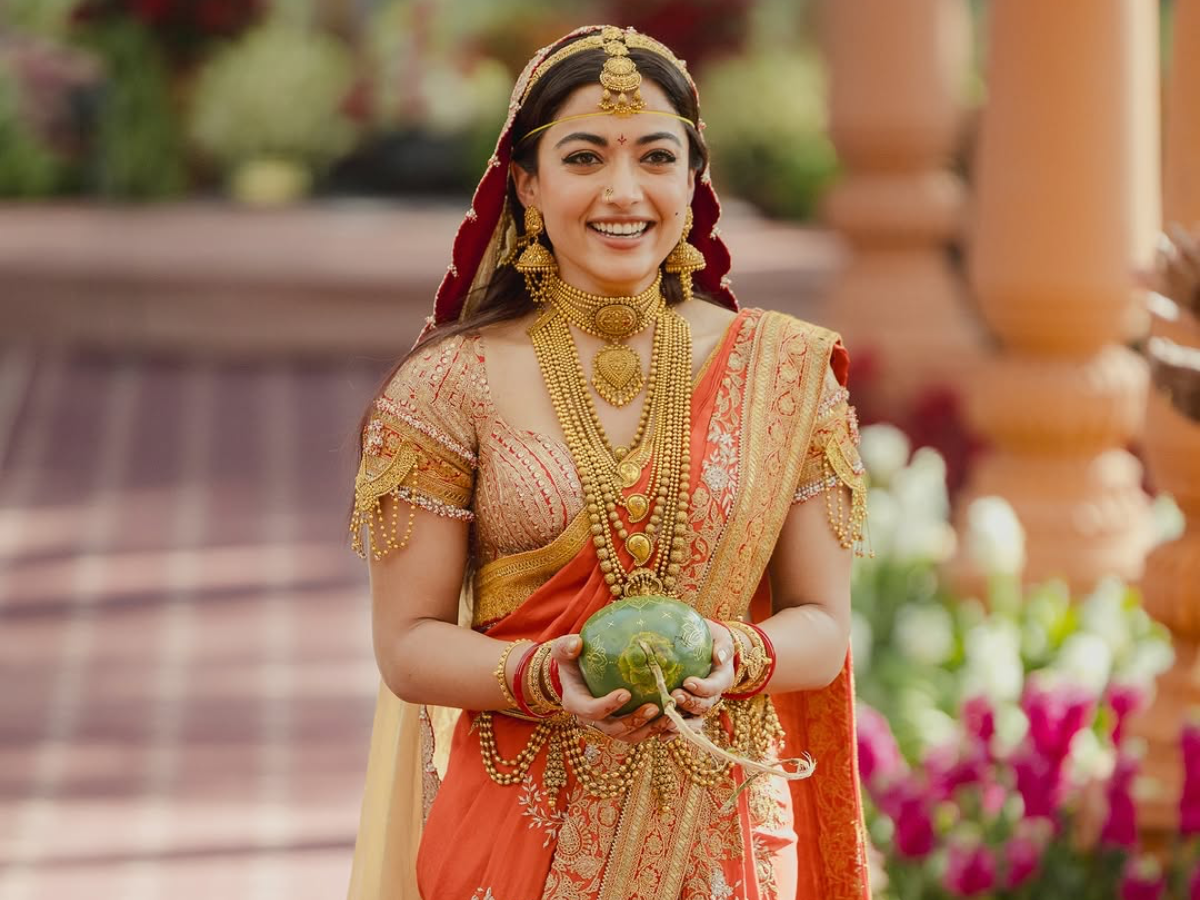 Rashmika Mandanna in an orange gold sari at her wedding. - Photo Gallery